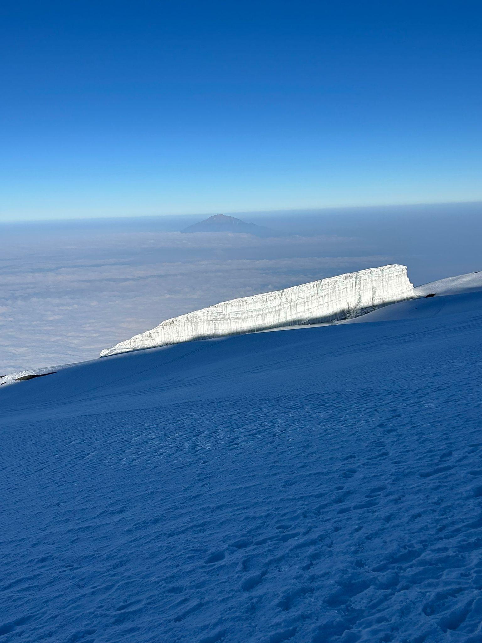 Massive ice wall at the summit plateau of Mount Kilimanjaro under a clear blue sky